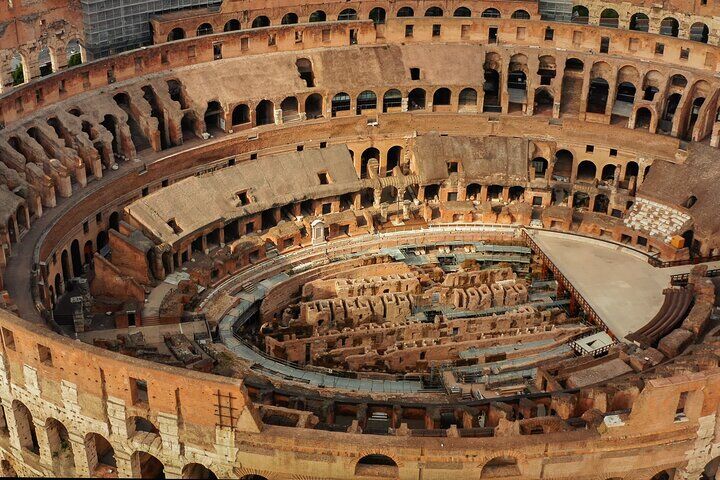 Wide view inside the Colosseum showing the network of underground corridors beneath the arena