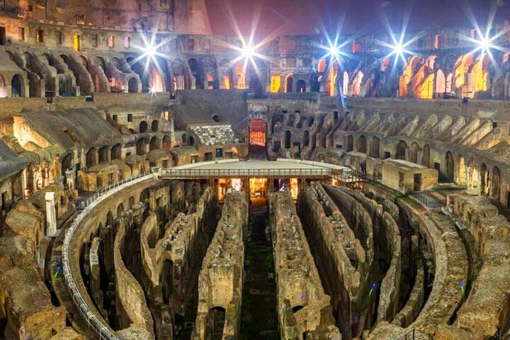 Colosseum interior illuminated at night with the underground corridors lit up